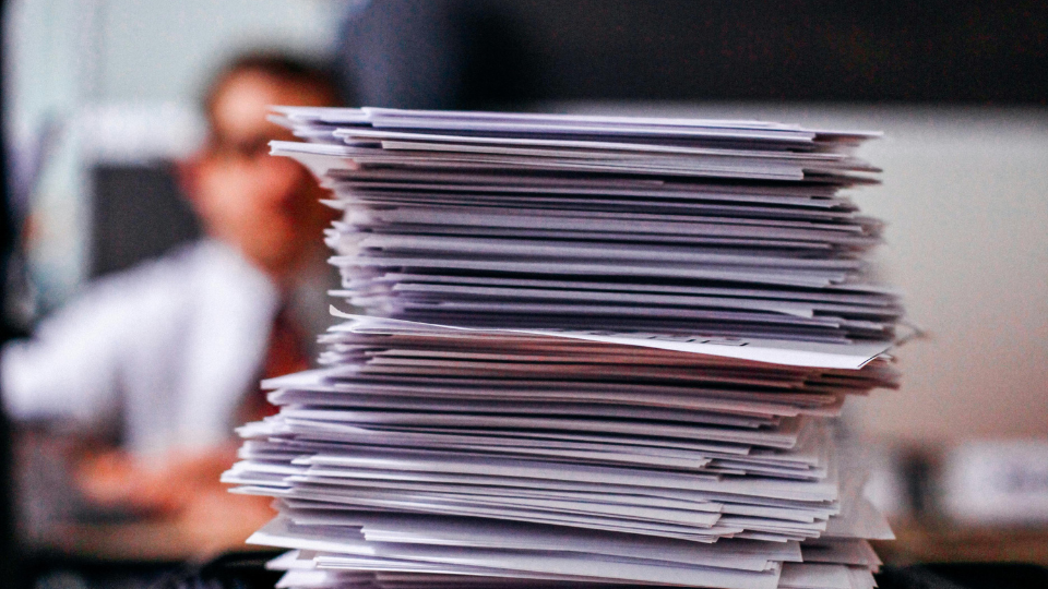 A pile of key income documents stacked on a desk