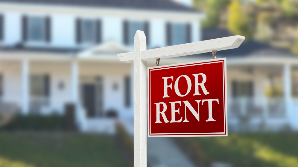A single-family rental property with a 'For Rent' sign out front