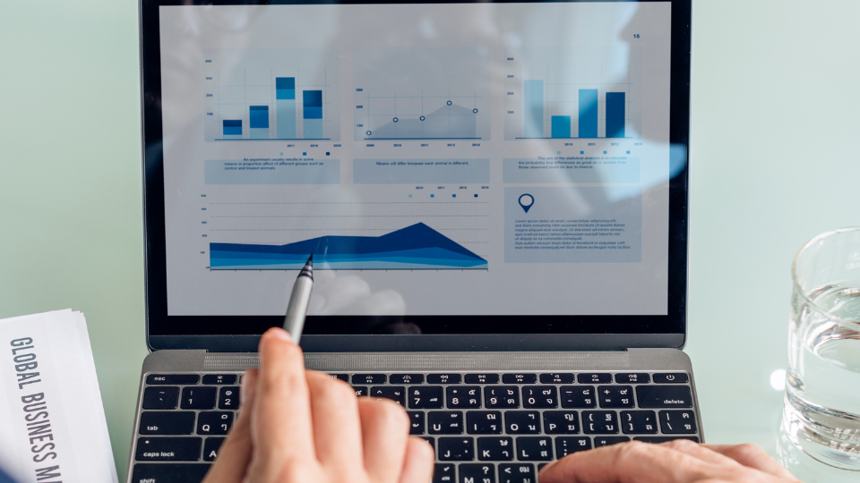 Two people review AI-powered mortgage lending software on a computer screen displaying loan data and performance metrics