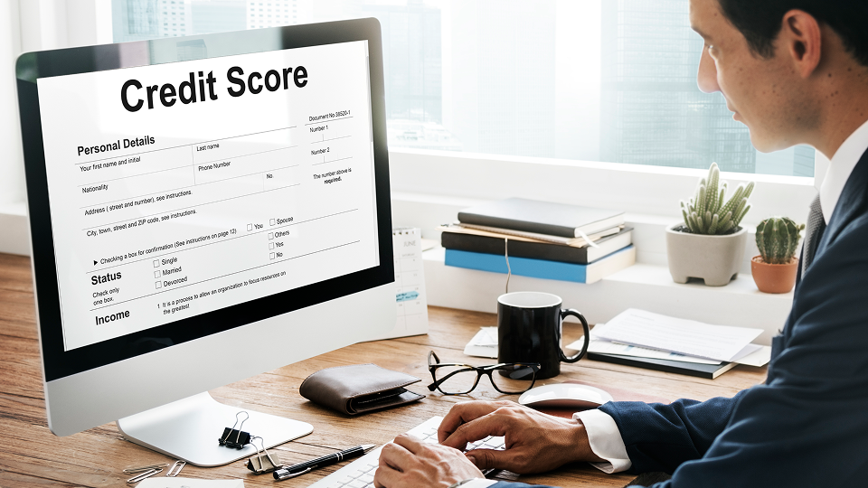 A person reviews credit score information on a desktop computer in an office setting