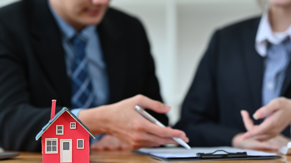 Two lenders look at documents on a clipboard together