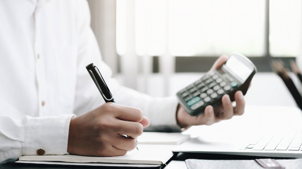 A lender calculates FHLMC rental income with a pen and a calculator