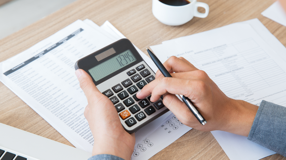 A person uses a calculator to calculate Freddie Mac asset depletion income