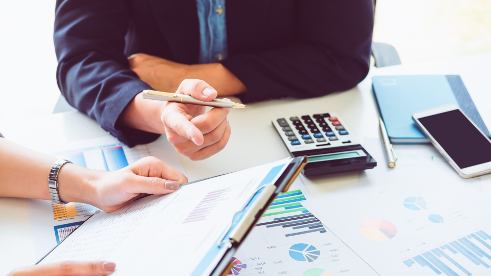 Two people sit at a table reviewing loan documents
