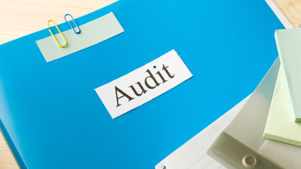 A close-up of a folder with the word “Audit” written on the front