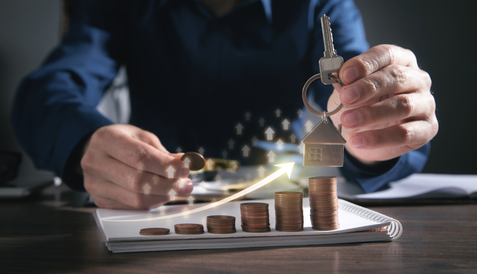A lender reviews documents with increasing stack of coins showing FHA income analysis